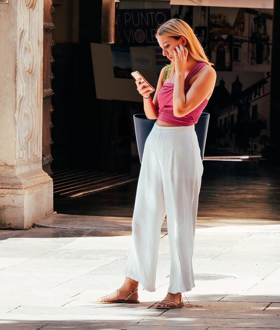 Mujer mirando el móvil en la Plaza de la Universidad de la UGR